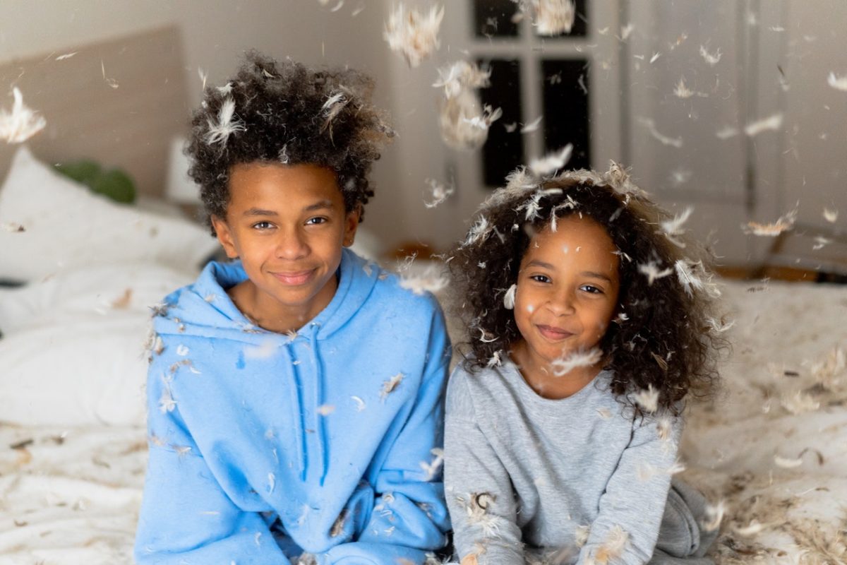 Happy siblings having a pillow fight