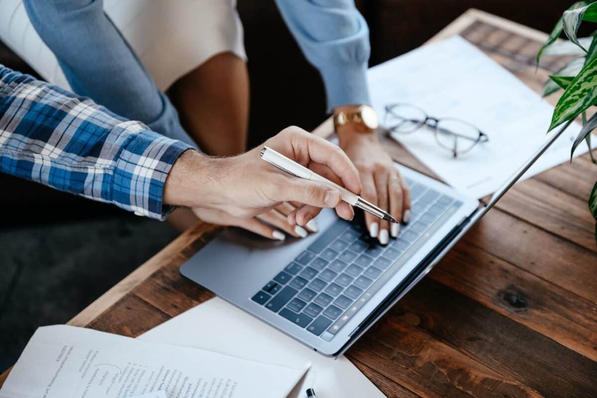 Two sets of hands using a computer and filing family court fees in Australia