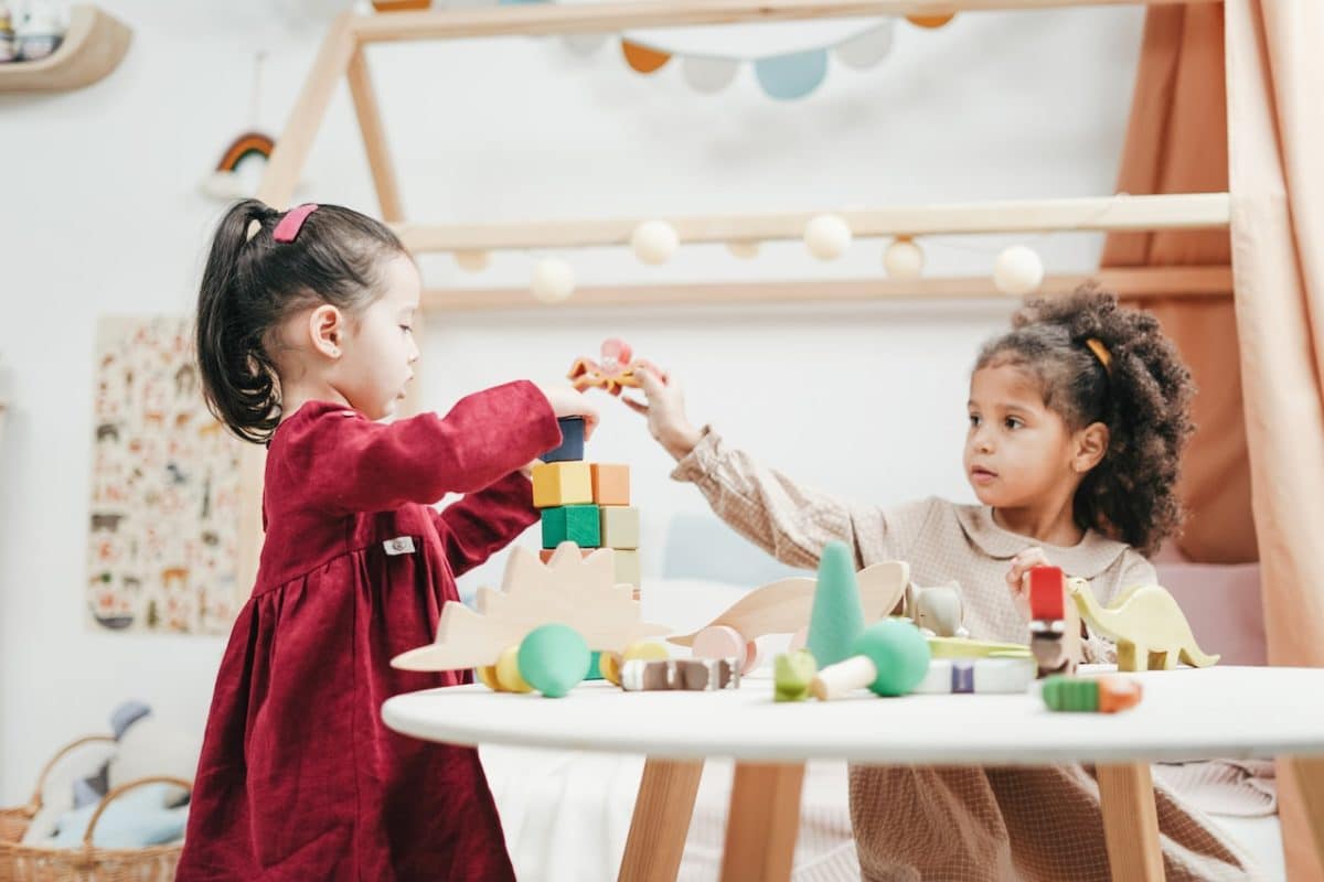 Two cute girls playing with toys showcasing good examples of co parenting arrangements.