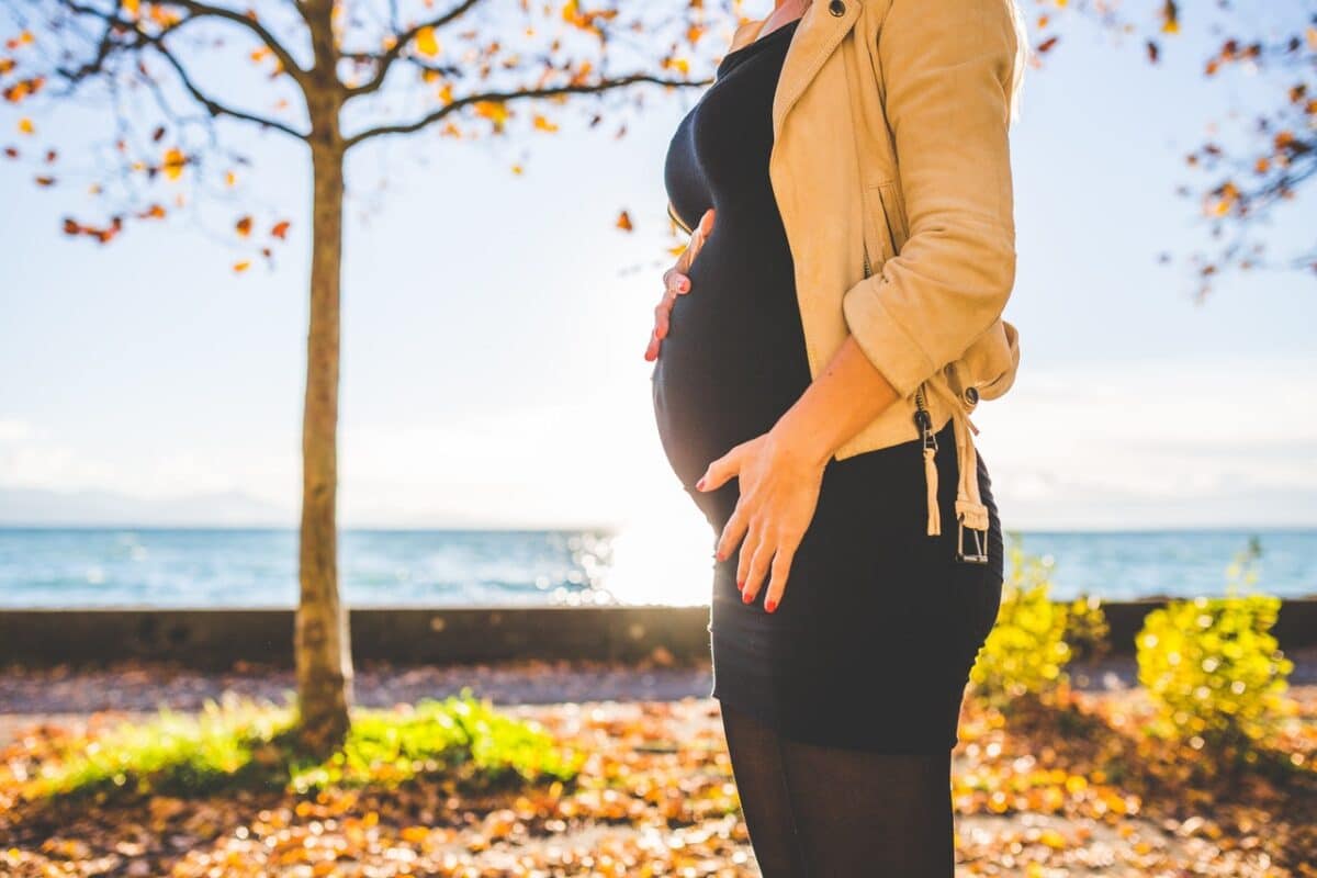 Pregnant woman standing in a park showcasing surrogacy laws in Australia