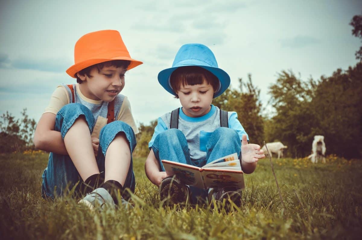 Two Financial Institutions reading in a meadow with bucket hats under a great example of good parenting arrangements and agreements